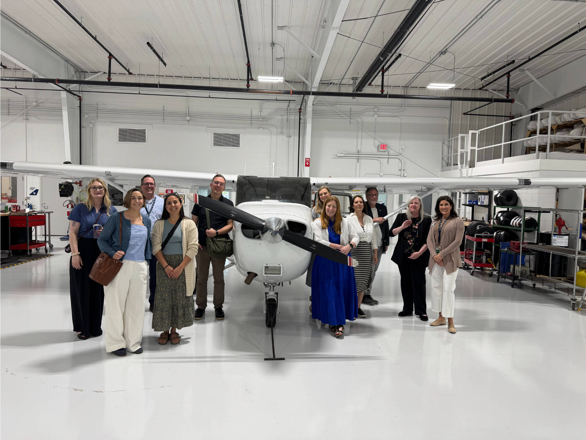 people in front of airplane in a hangar